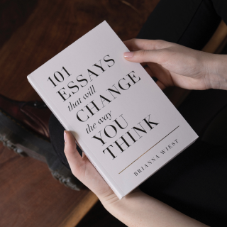Pessoa segurando com as duas mãos o livro 101 essays that will change the way you think de Brianna Wiest