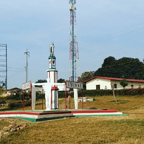 Uma estátua na cidade de Muramvya, com uma residência ao fundo