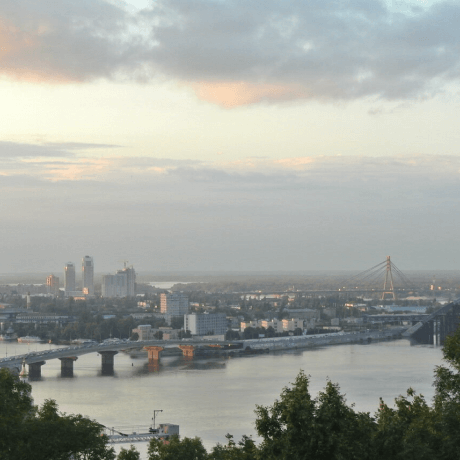Uma ponte sobre o rio Dnipro, com a cidade de Kiev, Ucrânia, ao fundo